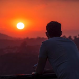 man standing watching sunset