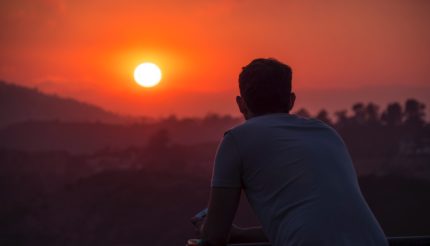 man standing watching sunset